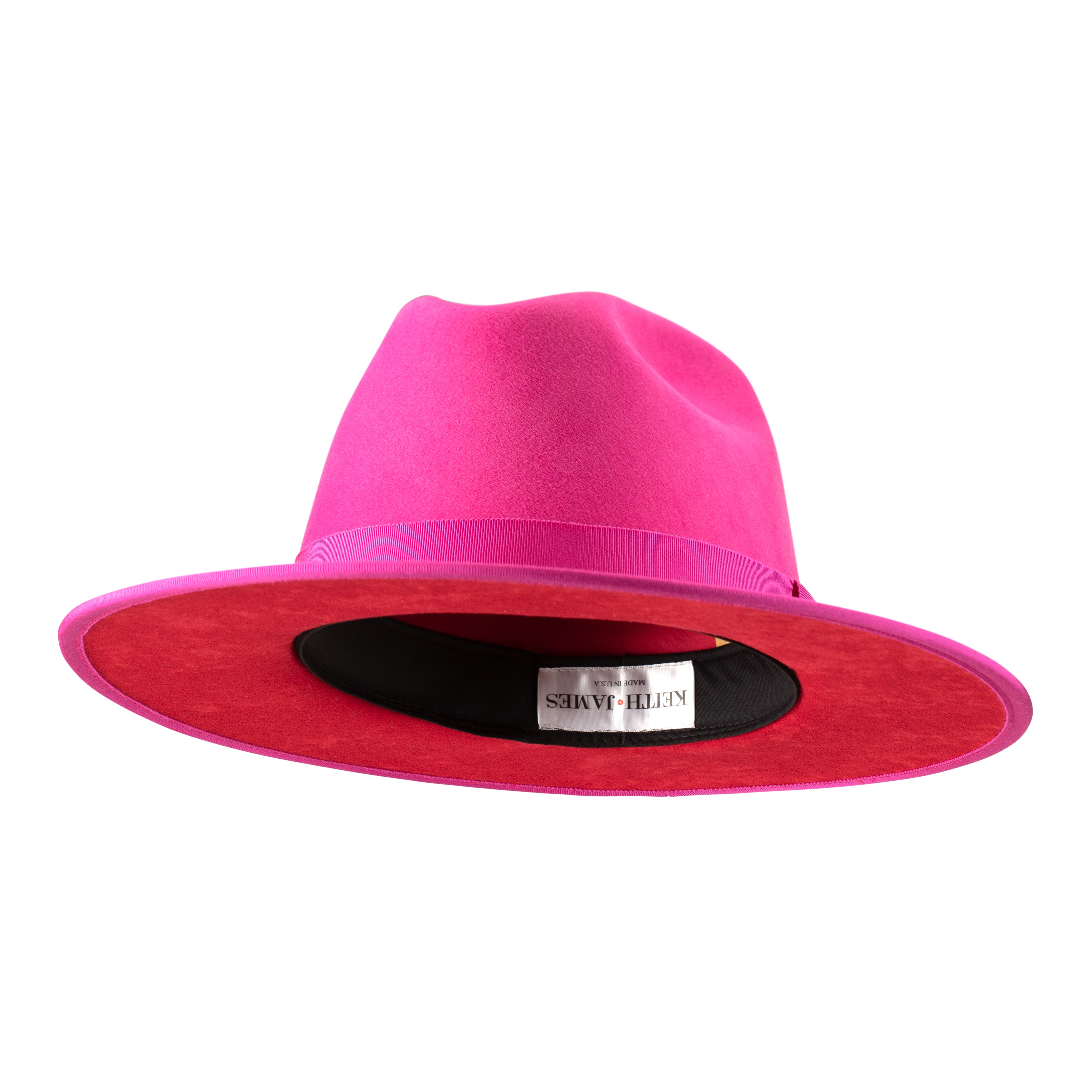 A hot pink fedora hat with a flat brim, classic ribbon trim, and a signature logo pin on the side.