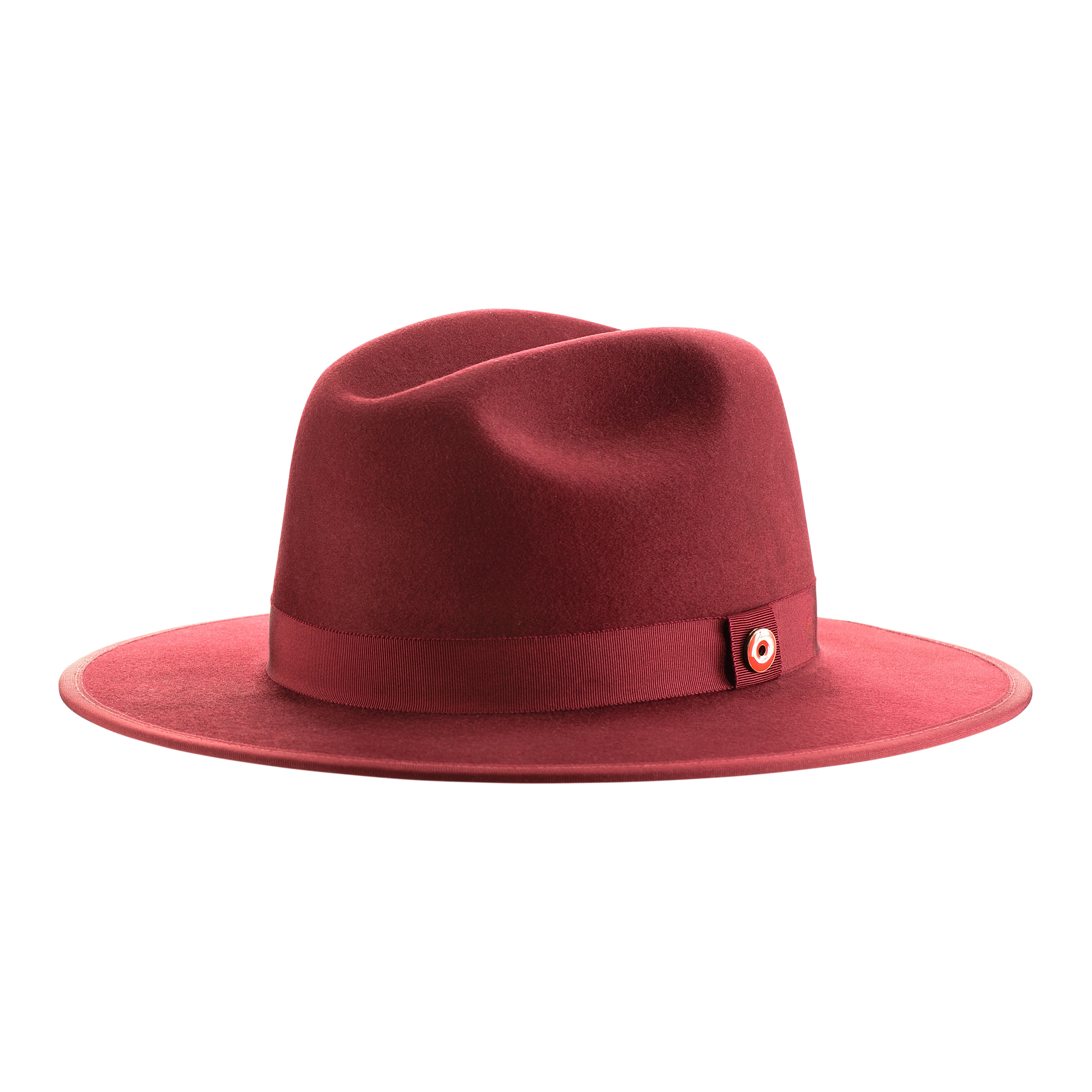 A maroon colored fedora hat with a flat brim and a classic ribbon trim, featuring a signature logo pin on the side.