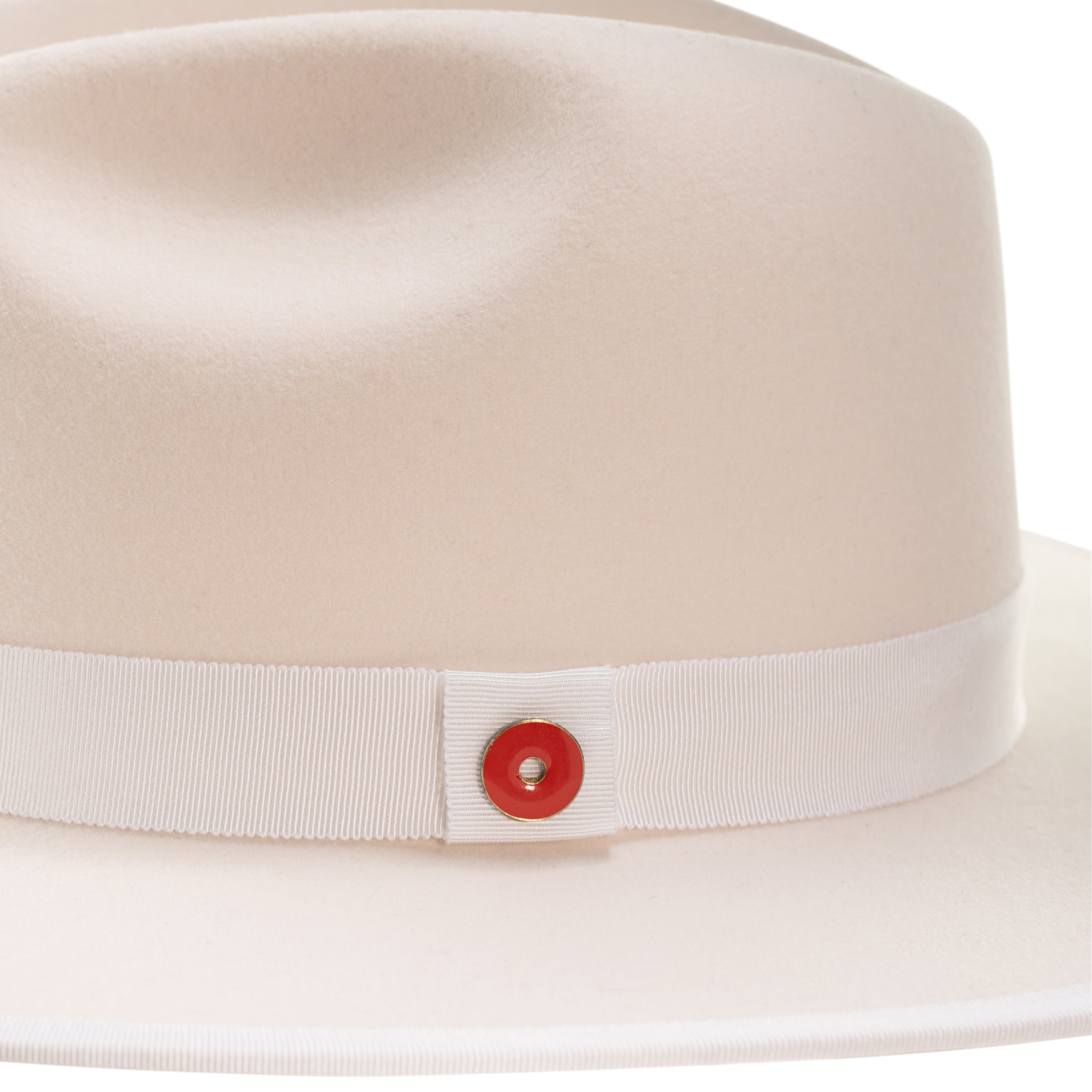 A snow white fedora hat with a pinched crown, flat brim, and bound edge. It includes a classic ribbon trim, a signature logo pin, and a red bottom brim.