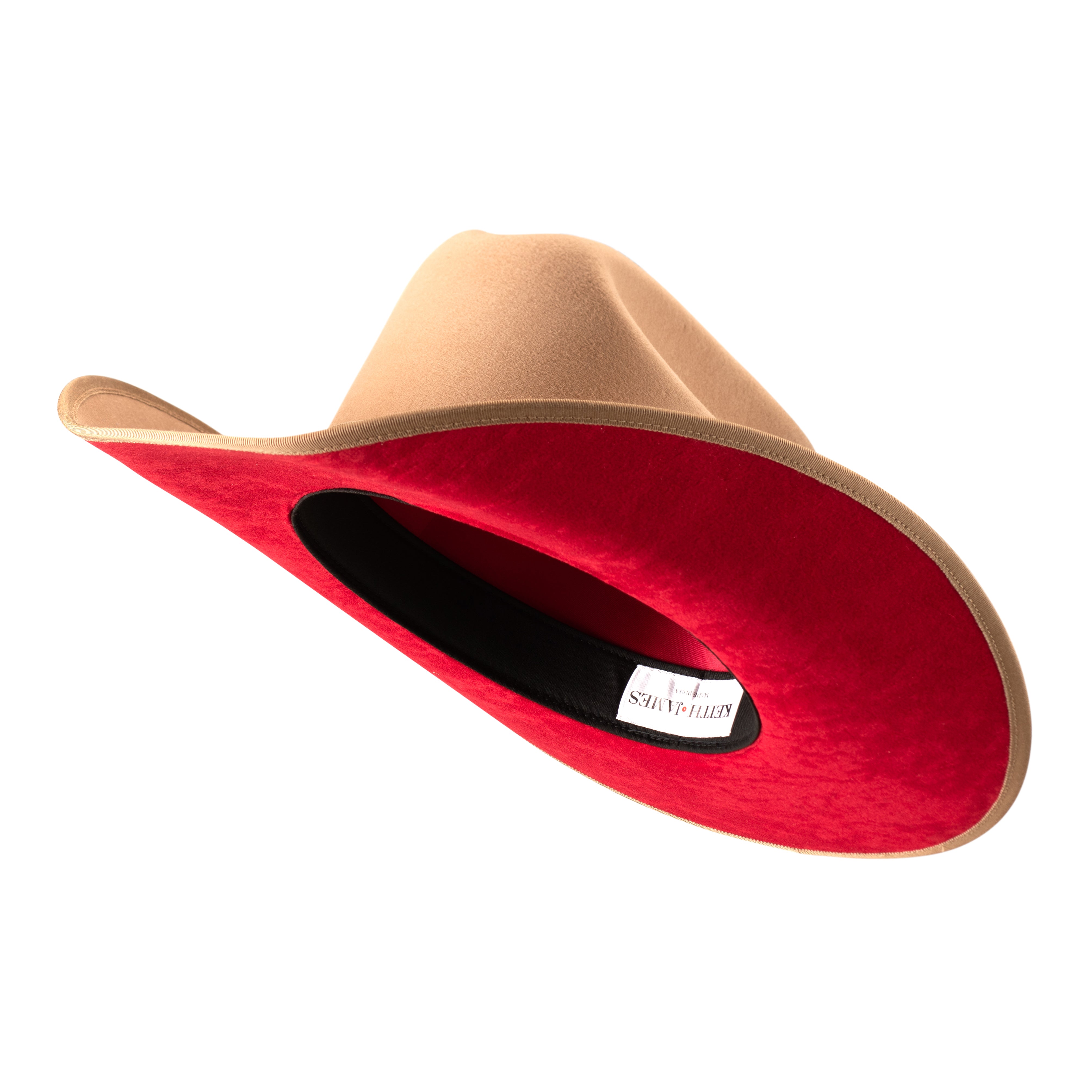 A golden honey colored cowboy hat with a red suede under brim and a hat pin.