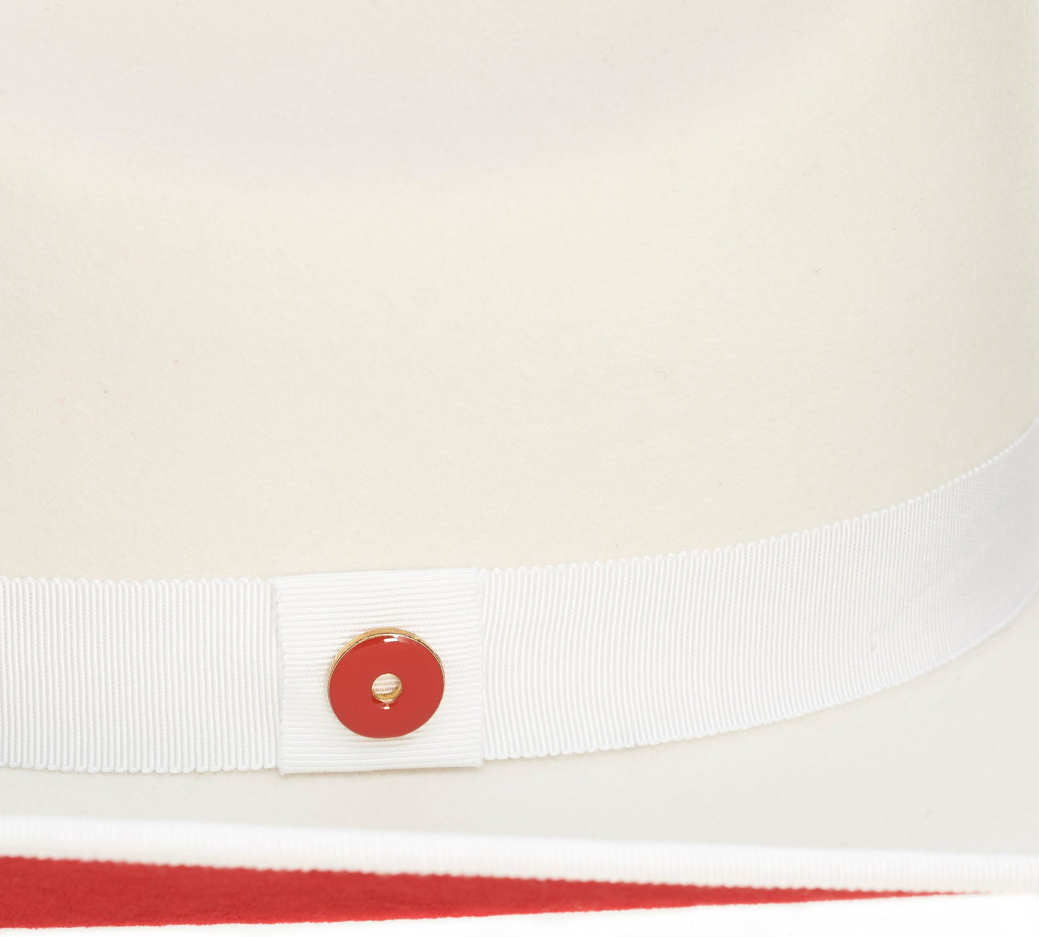 A white Western fedora with a red suede brim and a 'Keith And James' red circle logo pin.
